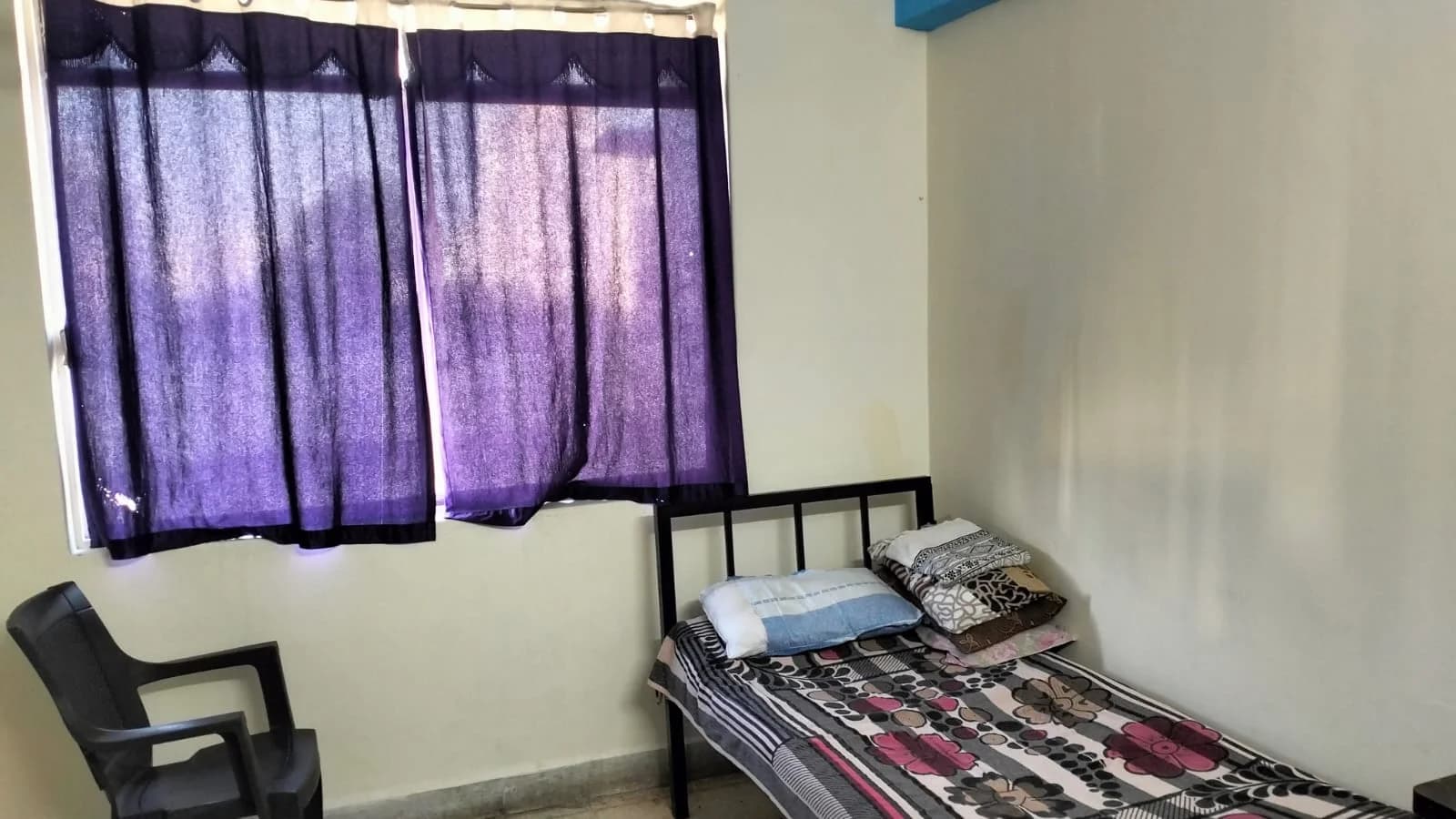 Mumbai ashram · single room with curtains and chair