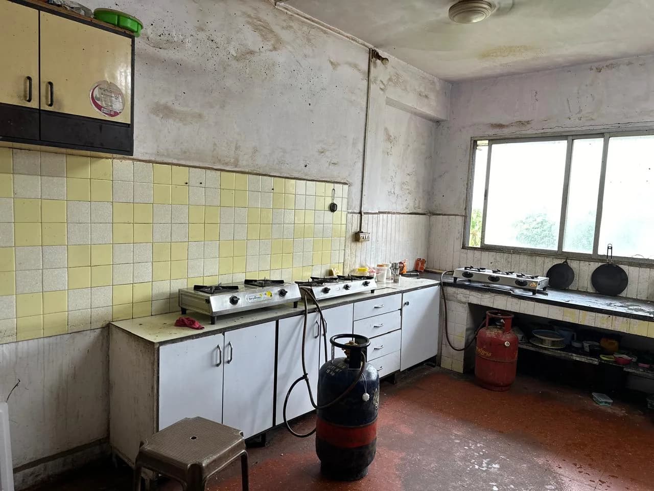 Mumbai ashram kitchen with gas cylinders and stoves