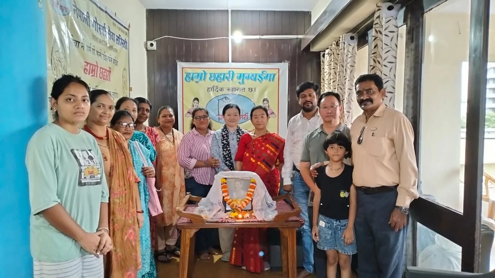 Tribute gathering with garlanded photo at the Mumbai ashram
